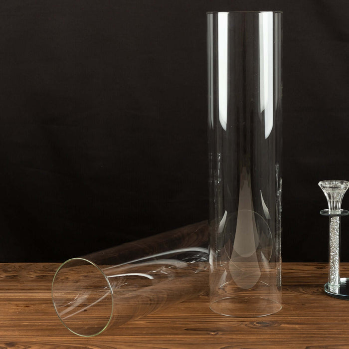 Clear glass vases in various sizes on a wooden surface.