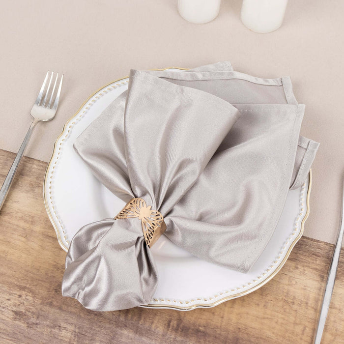 Elegant silver napkin elegantly tied on a decorative plate.