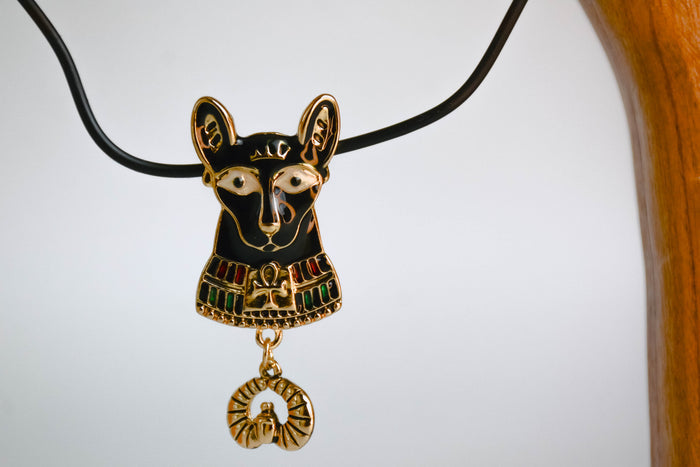 Bastet cat pendant hanging off of wooden arch