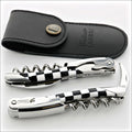 Chateau Laguiole Grand Cru Damier Corkscrew, top-down view of two corkscrews with black and white checkered handles and a black leather case. Handcrafted details, 100% Made in France.