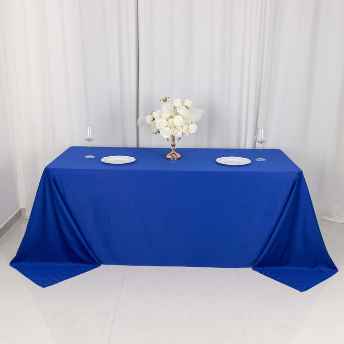 Blue tablecloth draped over a table with elegant floral centerpiece and glassware.