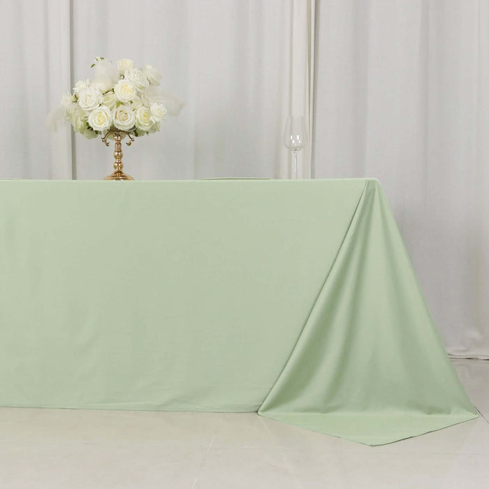 Mint green tablecloth draped elegantly on a table with a floral centerpiece.